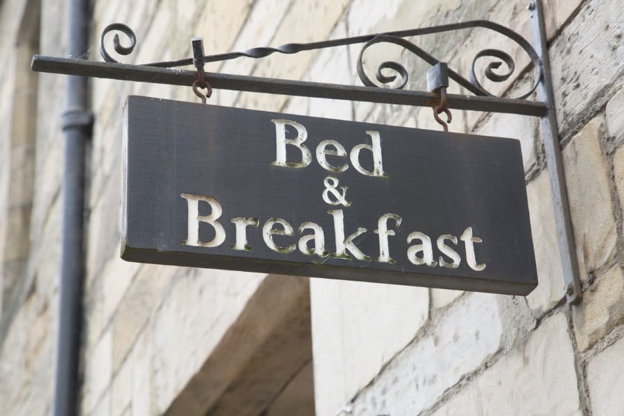 Ein Metallschild an einer Hauswand mit der Beschriftung Bed and Breakfast