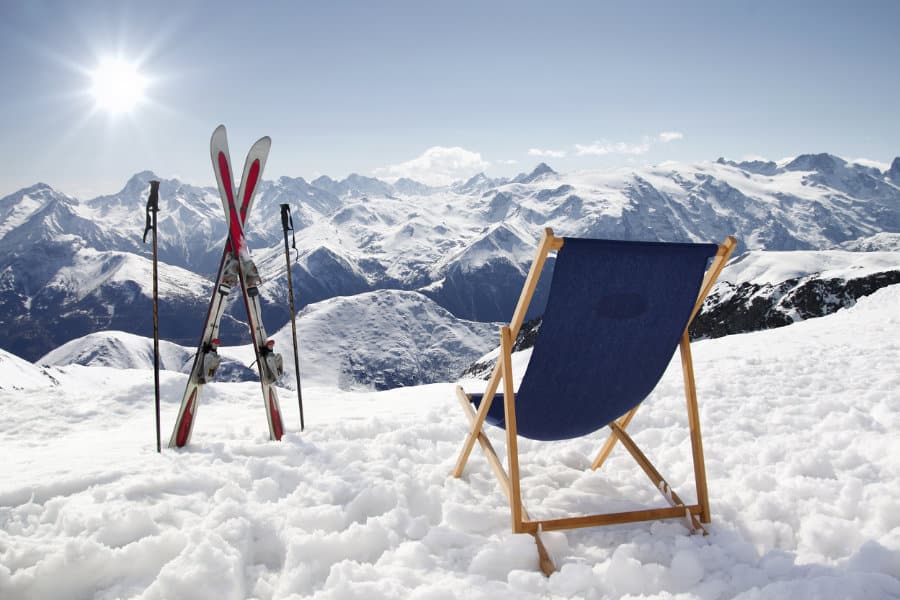 Das Kategoriebild Winterurlaub zeigt einen Klappstuhl im Schnee mit Ausblick auf die schneesicheren Berge im Skiurlaub.